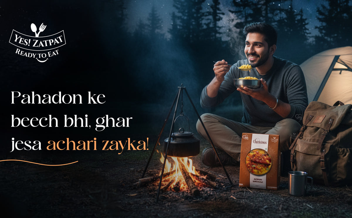 Man camping by a fire, eating from a box labeled 'YESI ZATPAY', with text in Hindi.