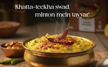 Steaming dish of yellow rice with a red chili pepper on top, garnished with green herbs, in a brass bowl. Text overlay in a foreign language.