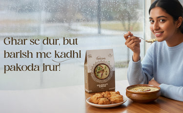 Woman eating from a bowl with a box of 'Chakram' snacks on a table by a window.