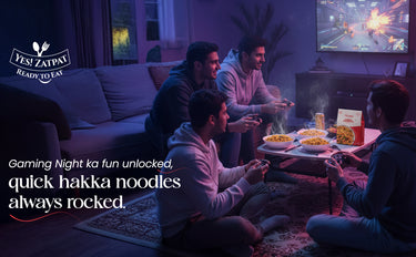 People playing video games in a living room with food and a TV screen.