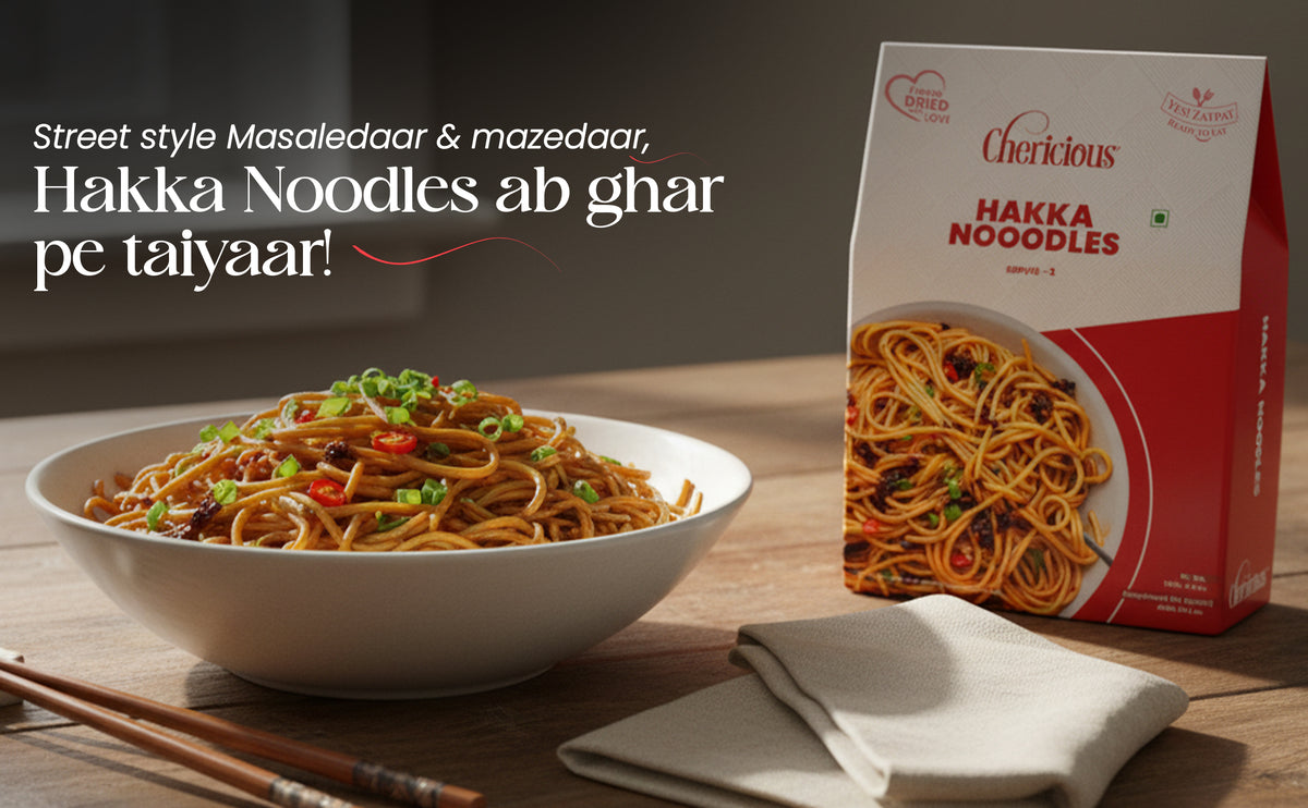 Bowl of Hakka Noodles with a box of Cherlicious Hakka Noodles on a wooden table.