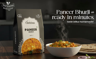 Packaged Paneer Bhurji with a bowl of the dish on a wooden table.