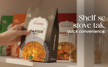 Hand holding a package of 'Cherishious Paneer' with other packages in the background.