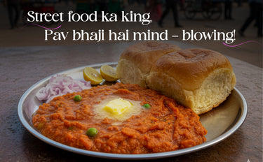 Plate of Pav bhaji with a bun, lemon, and onions on a wooden table.