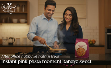 Man and woman cooking together in a kitchen with a pink pasta box on the counter.