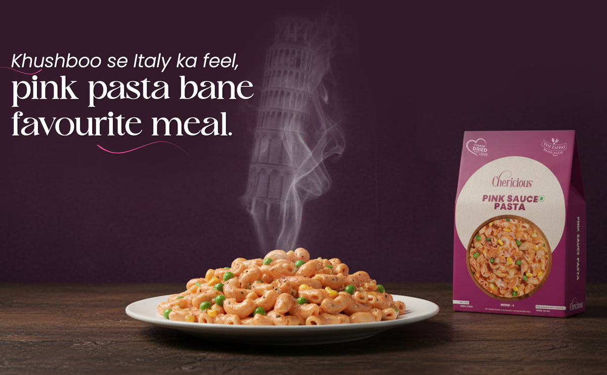 Pink pasta on a plate with a box of pink sauce pasta against a dark background