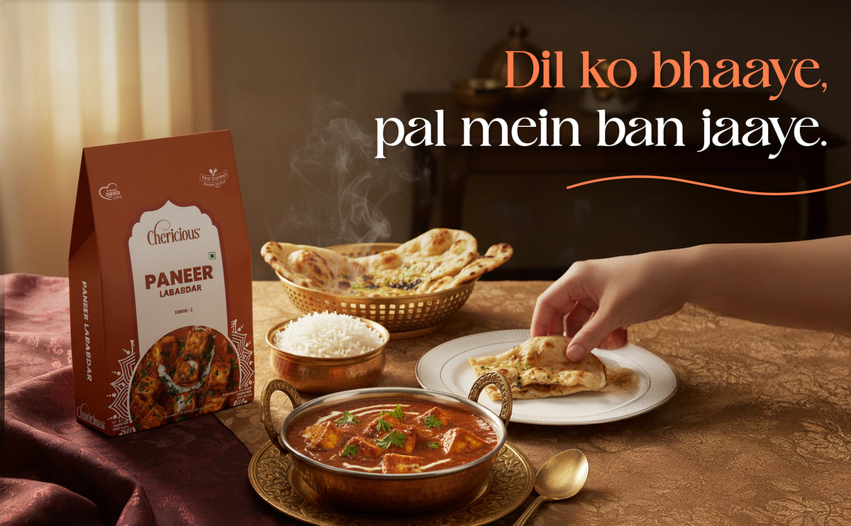 Culinary scene with a box of 'Cherishous' paneer, a bowl of curry, naan, and rice on a table.