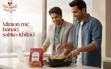 Two men cooking together with a package of Paner in the foreground, featuring the Yes Zaapay brand.