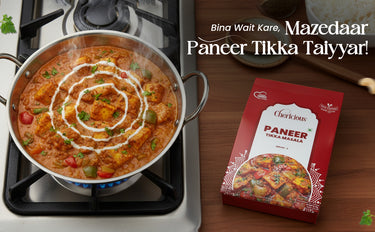 Stir-fry dish with paneer tikka masala on a stove, next to a box of Cheeky's Paneer Tikka Masala.