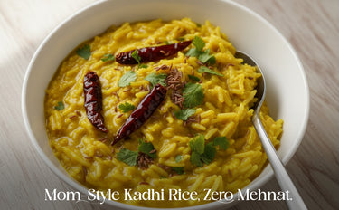 Bowl of yellow rice dish with red chilies and a spoon on a light wooden surface.