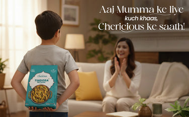 Child holding a Cherieous Tindora package with a woman clapping in a living room.