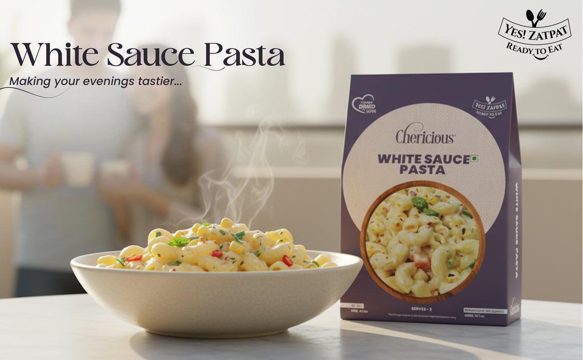 Bowl of white sauce pasta with a box labeled 'White Sauce Pasta' on a blurred background.